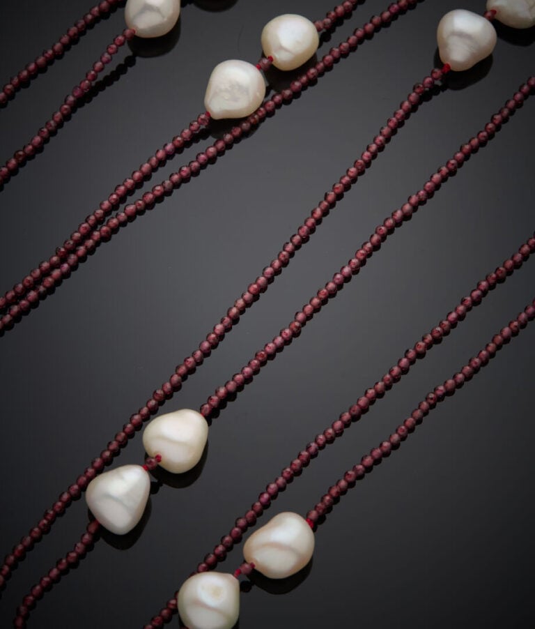 SAUTOIR composé d'un rang de perles de grenats facettées et 18 perles de cultur…