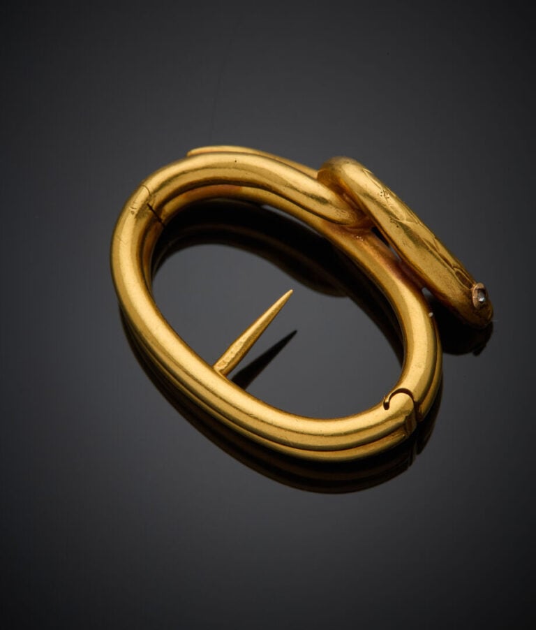 SERRE FOULARD "serpent" en or jaune (750‰) partiellement ciselé, les yeux serti…