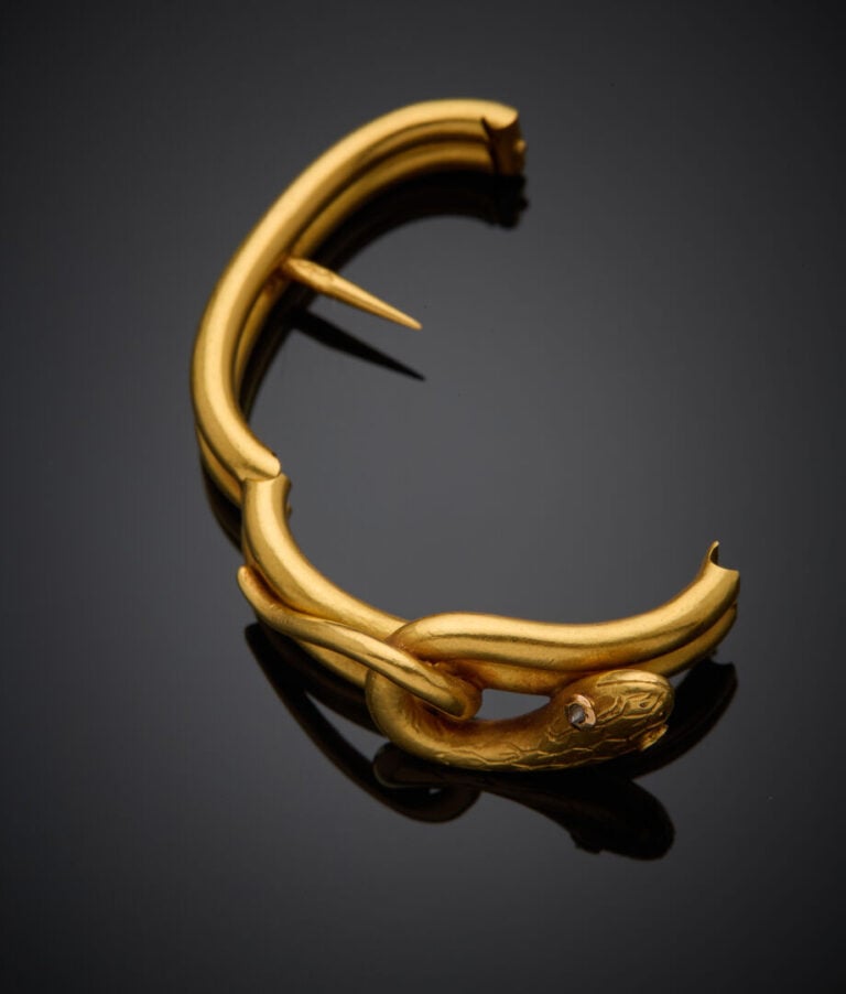 SERRE FOULARD "serpent" en or jaune (750‰) partiellement ciselé, les yeux serti…