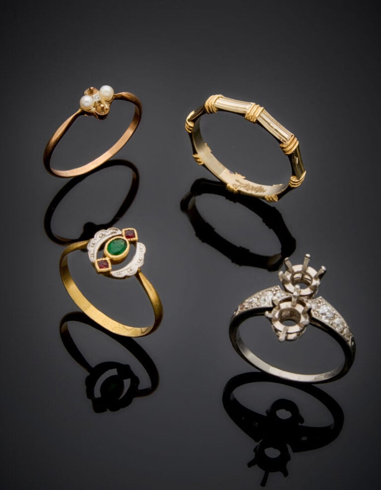 Trois BAGUES trois ors (750‰) dont une ALLIANCE, serti de pierres vertes et rou…