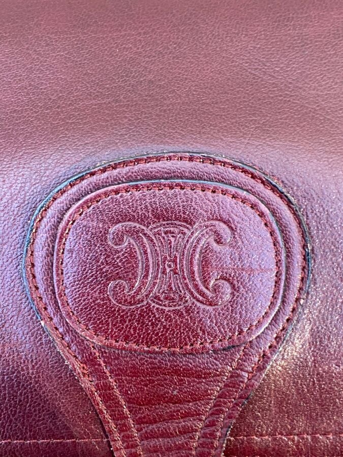 CELINE - Sac gibecière à bandoulière en cuir bordeaux à monogramme estampé. le…