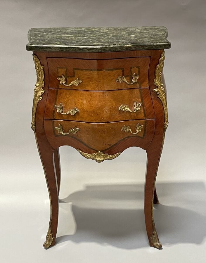 Chevet en placage de marqueterie et placage de loupe de forme galbée ; il ouvre…