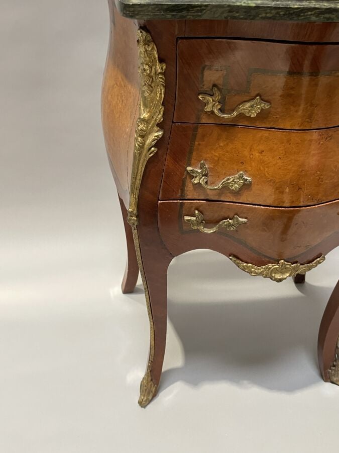 Chevet en placage de marqueterie et placage de loupe de forme galbée ; il ouvre…
