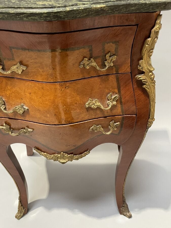Chevet en placage de marqueterie et placage de loupe de forme galbée ; il ouvre…