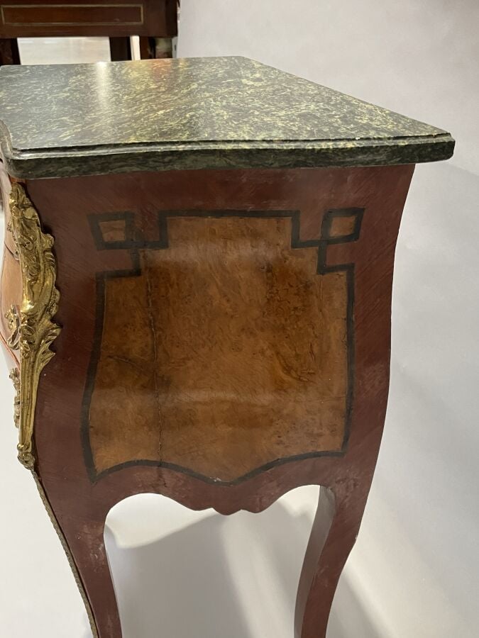 Chevet en placage de marqueterie et placage de loupe de forme galbée ; il ouvre…