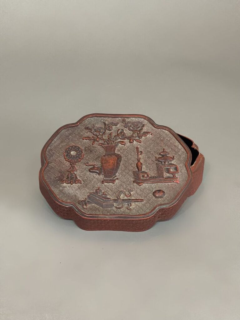 Chine - Boite polylobée en bois laqué rouge à décor scuplté en relief de mobili…