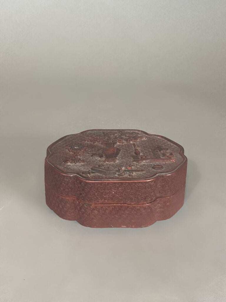 Chine - Boite polylobée en bois laqué rouge à décor scuplté en relief de mobili…