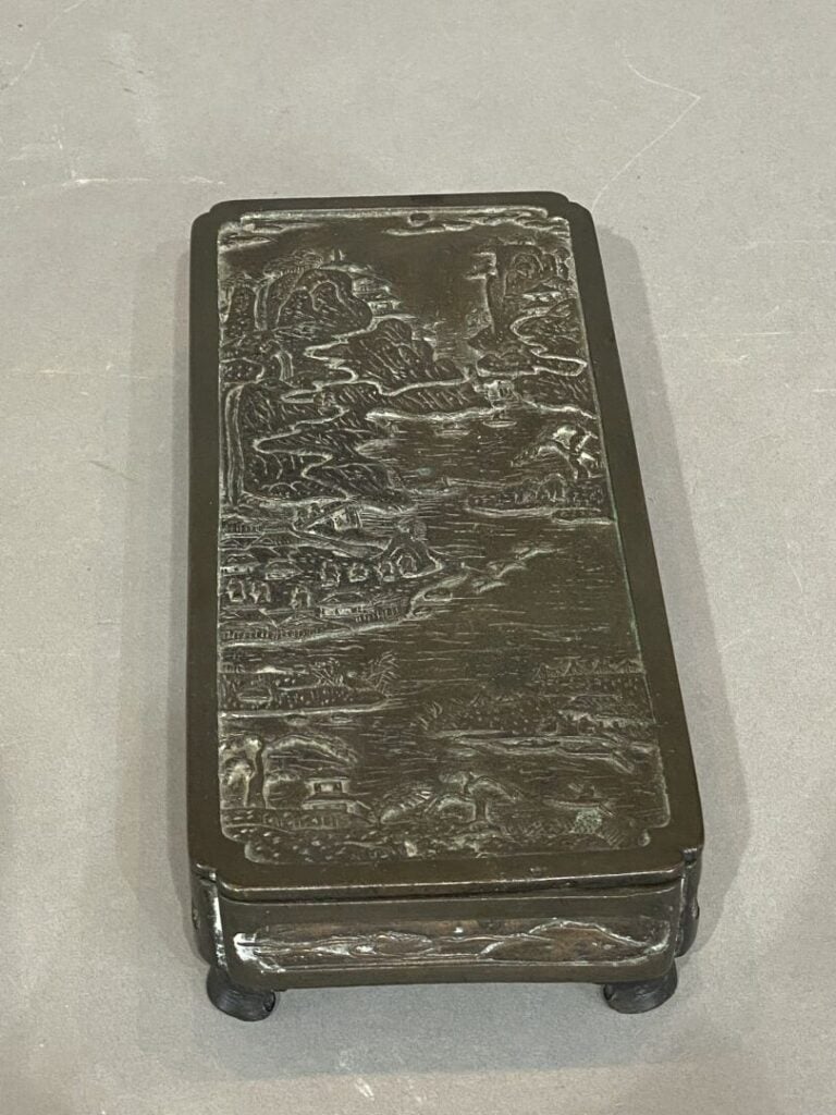 Chine - Boite rectangulaire en bronze à décor en léger rélief d'un village au b…