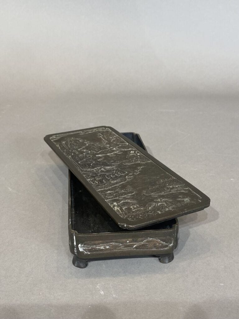Chine - Boite rectangulaire en bronze à décor en léger rélief d'un village au b…