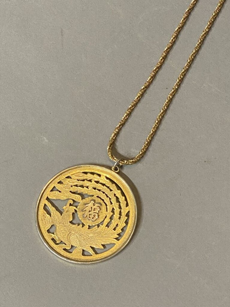 Chine - Pendentif en métal doré à décor ajouré d'un phénix et caractère. - D: 6…