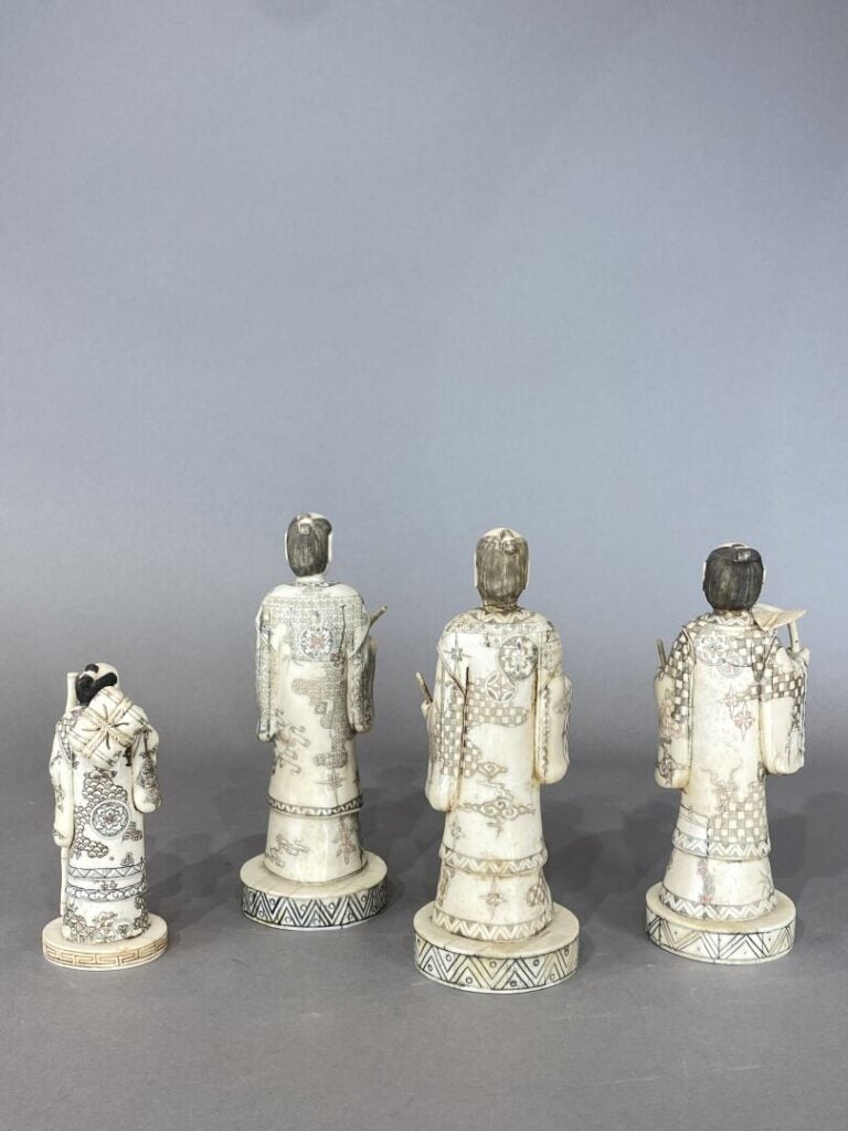 Ensemble de quatres statues en os figurant des hommes debout en costume tenant…