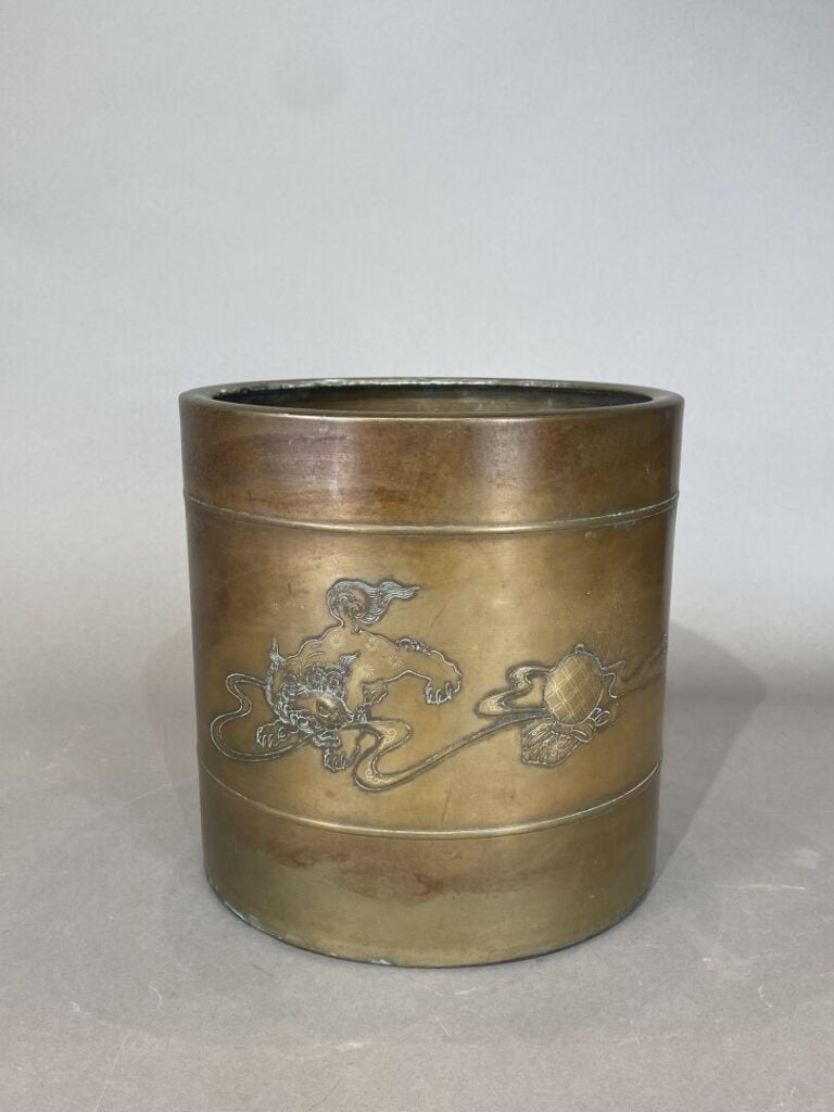 Japon - Cache-pot de forme cylindrique en bronze doré à décor de shishi jouant…