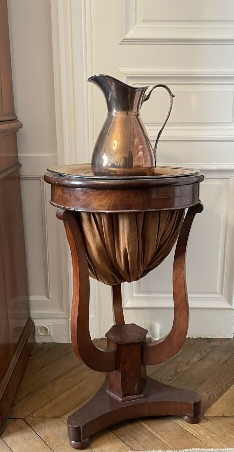 Meuble à couture en acajou et placage d'acajou sur piétement tripode .On joint…