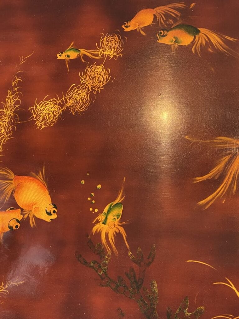 Thanh Le, - Table basse en bois laqué rouge à décor doré de poissons nageant pa…