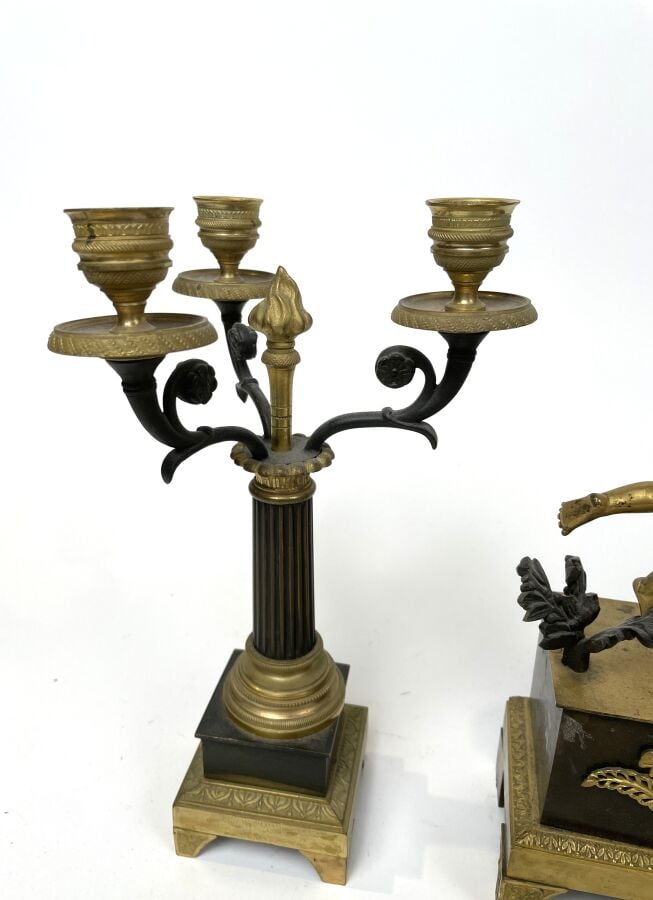 GARNITURE DE CHEMINEE comprenant une pendule à décor en relief d'un amour ailé…