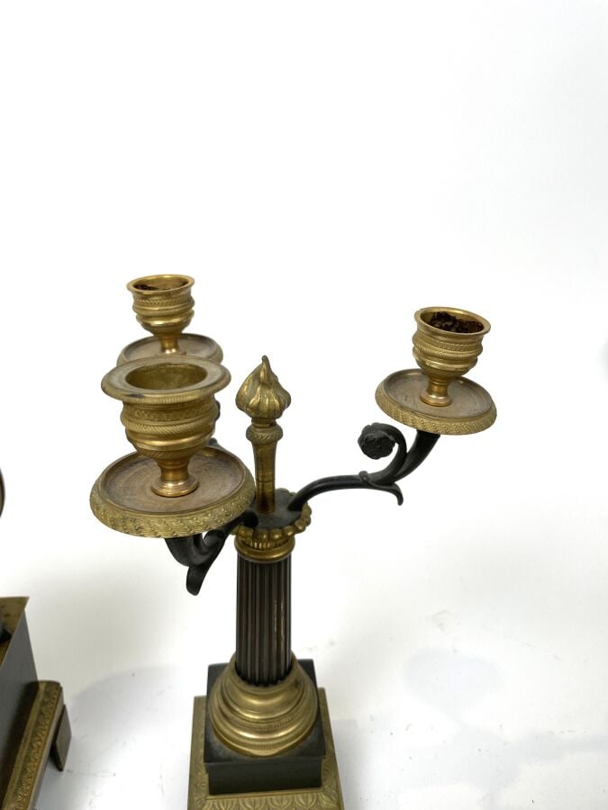 GARNITURE DE CHEMINEE comprenant une pendule à décor en relief d'un amour ailé…