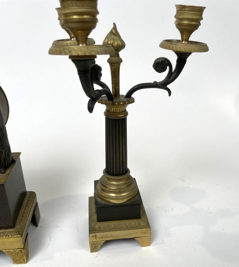 GARNITURE DE CHEMINEE comprenant une pendule à décor en relief d'un amour ailé…