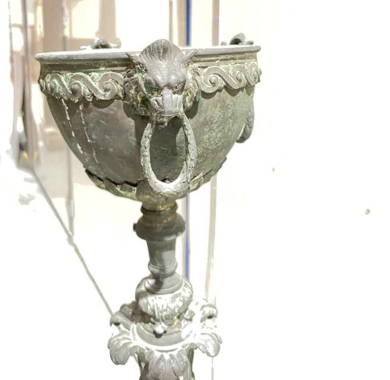 LAMPADAIRE en métal patiné vert, piètement tripode à décor de têtes de boucs te…