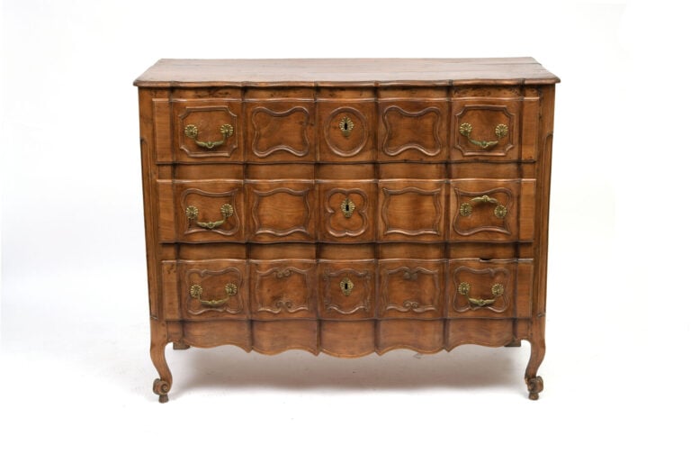 Commode à façade arbalète en noyer ouvrant à trois tiroirs à décor d'encadremen…