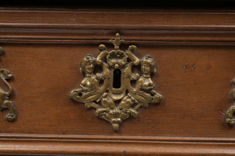 Commode en noyer mouluré et sculpté ouvrant en façade à trois tiroirs, les mont…