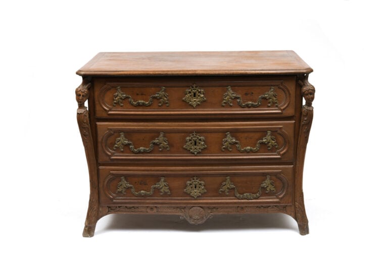 Commode en noyer mouluré et sculpté ouvrant en façade à trois tiroirs, les mont…