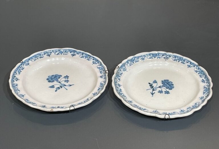 MOUSTIERS - Paire d'assiettes à bord contourné en faïence décorée en camaïeu bl…
