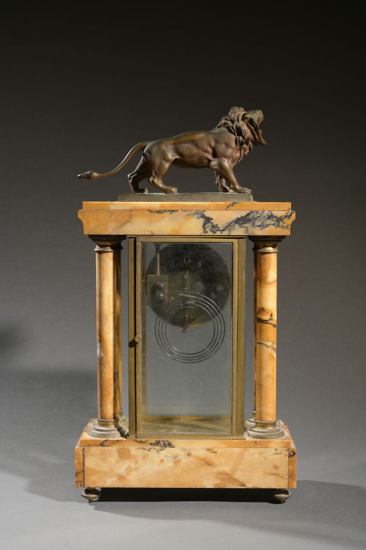 Pendule portique en marbre jaune de Sienne sommée d'un lion en bronze patiné si…