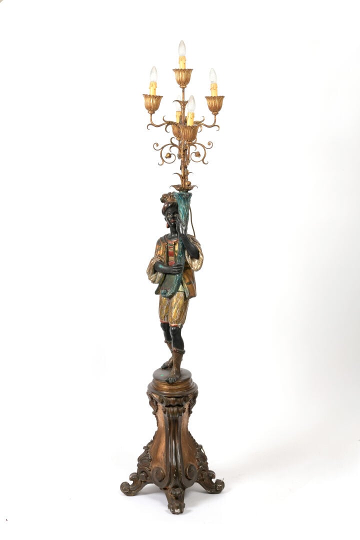 Porte-torchère en bois sculpté polychrome et doré figurant un Nubien soutenant…