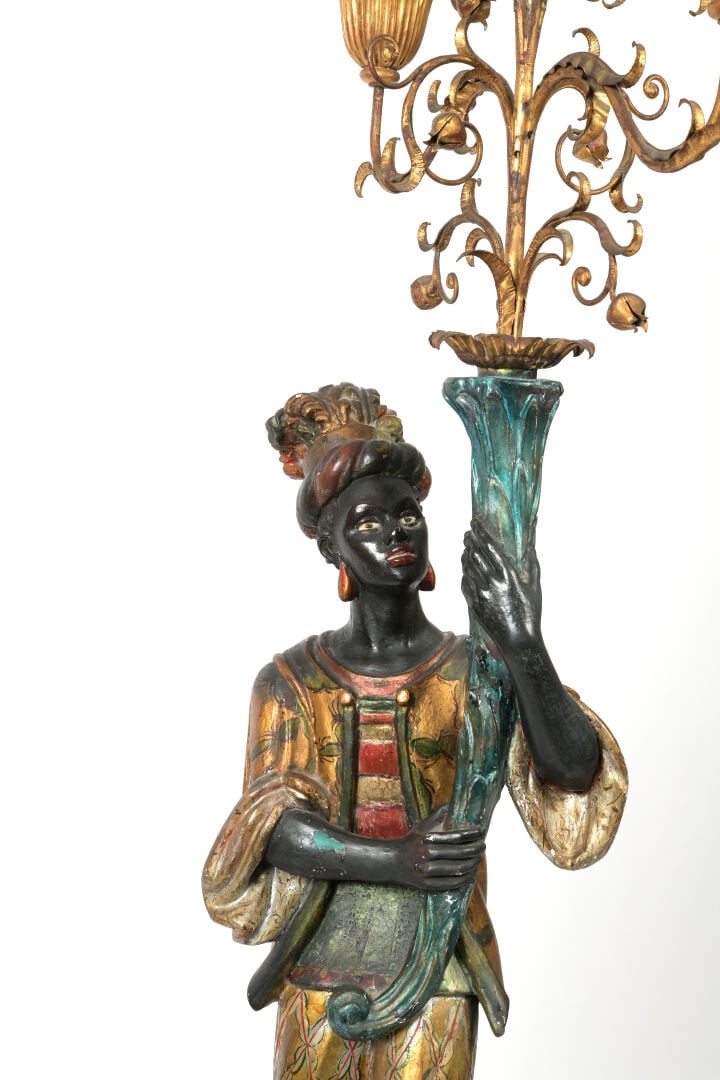 Porte-torchère en bois sculpté polychrome et doré figurant un Nubien soutenant…
