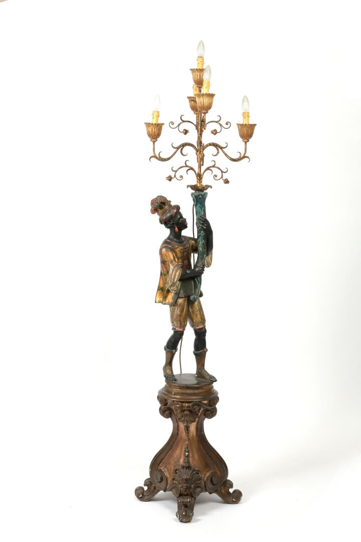 Porte-torchère en bois sculpté polychrome et doré figurant un Nubien soutenant…