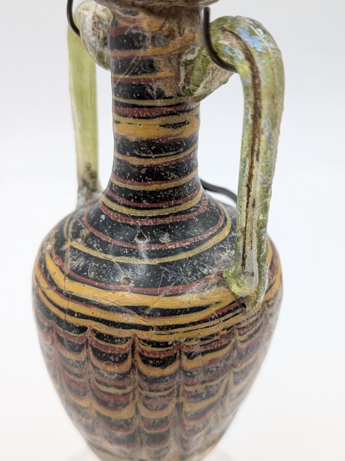 Amphorisque à panse tronconique terminée par un bouton, elle présente un décor…