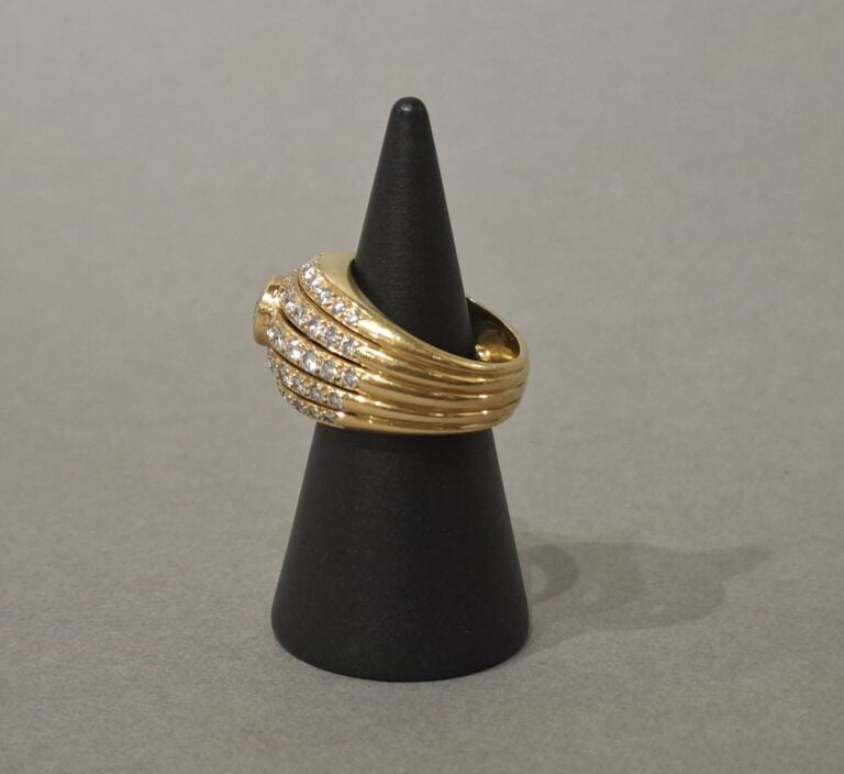 Bague dôme en or jaune (750) centrée d'un diamant taille brillant en serti clos…