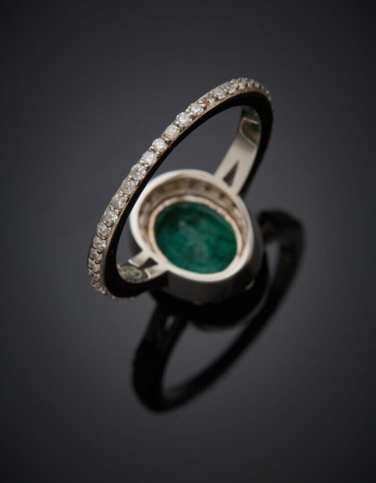 BAGUE en or gris (375‰) 9 carats, serti d'une émeraude ovale, le corps entièrem…