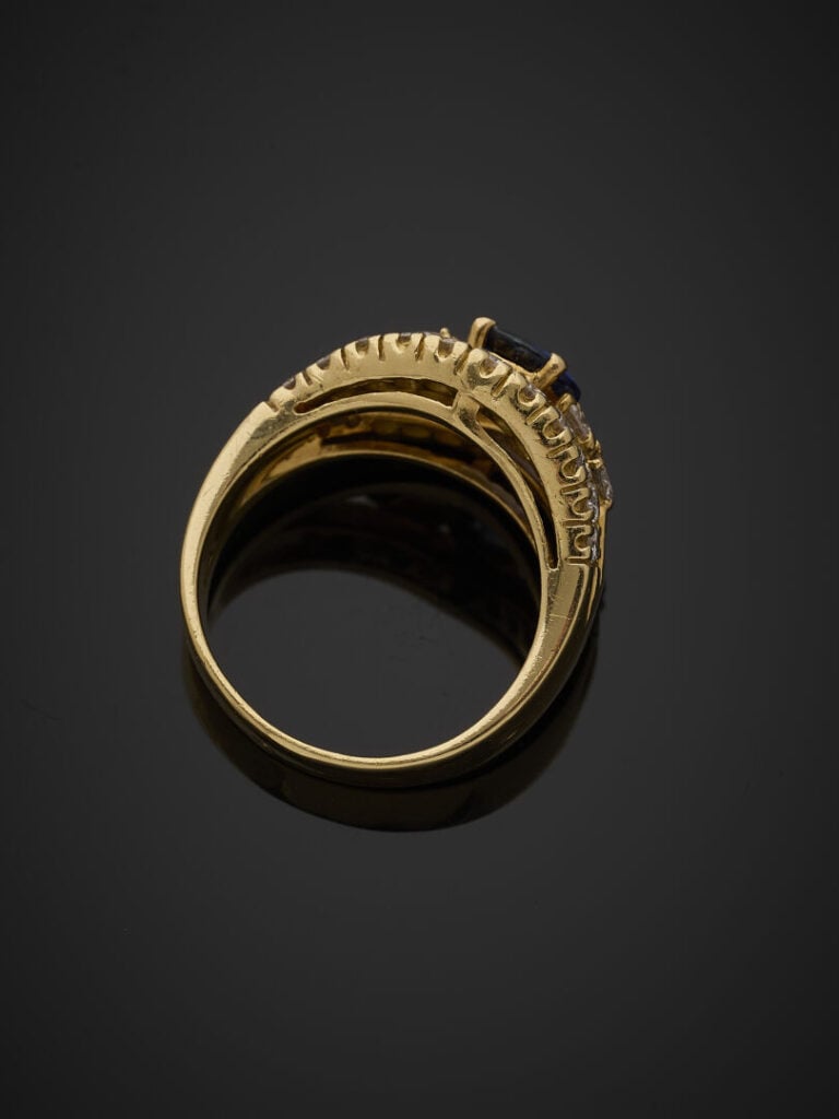 BAGUE en or jaune (750‰) ajouré, centré d'un saphir ovale (très légères égrisur…