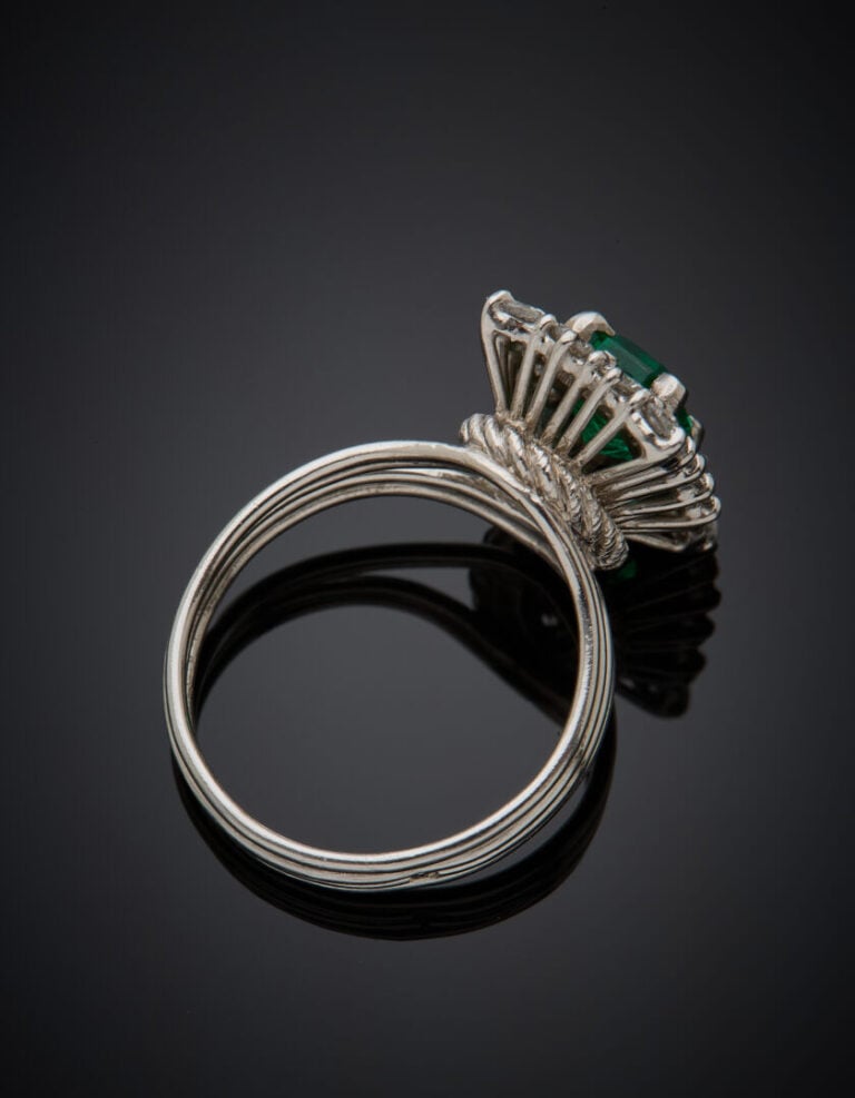 BAGUE en platine (950‰) serti d'une émeraude taillée à degrés, entourée de diam…