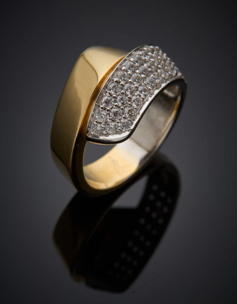 BAGUE "ruban" asymétrique en or jaune et or gris (750°/°°) partiellement pavée…