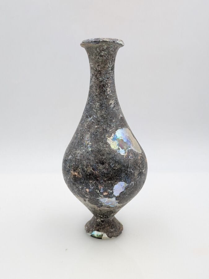Bouteille à panse piriforme au col concave et pied tronconique. - Verre à épais…