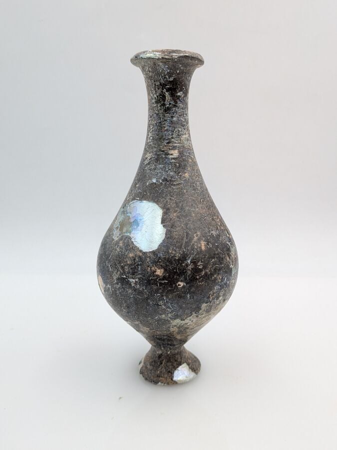 Bouteille à panse piriforme au col concave et pied tronconique. - Verre à épais…