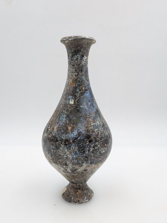 Bouteille à panse piriforme au col concave et pied tronconique. - Verre à épais…
