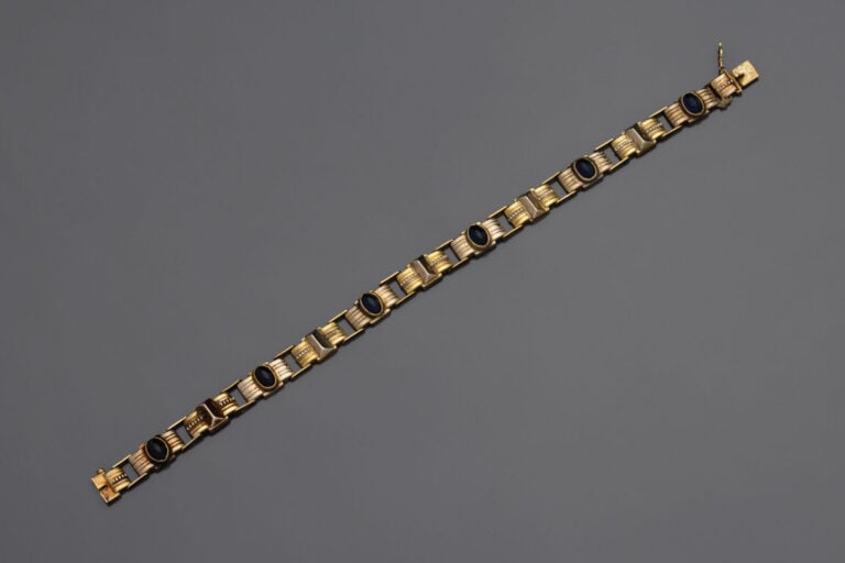 BRACELET géométrique articulé en or jaune (750°/°°) rainuré et cranté, serti de…