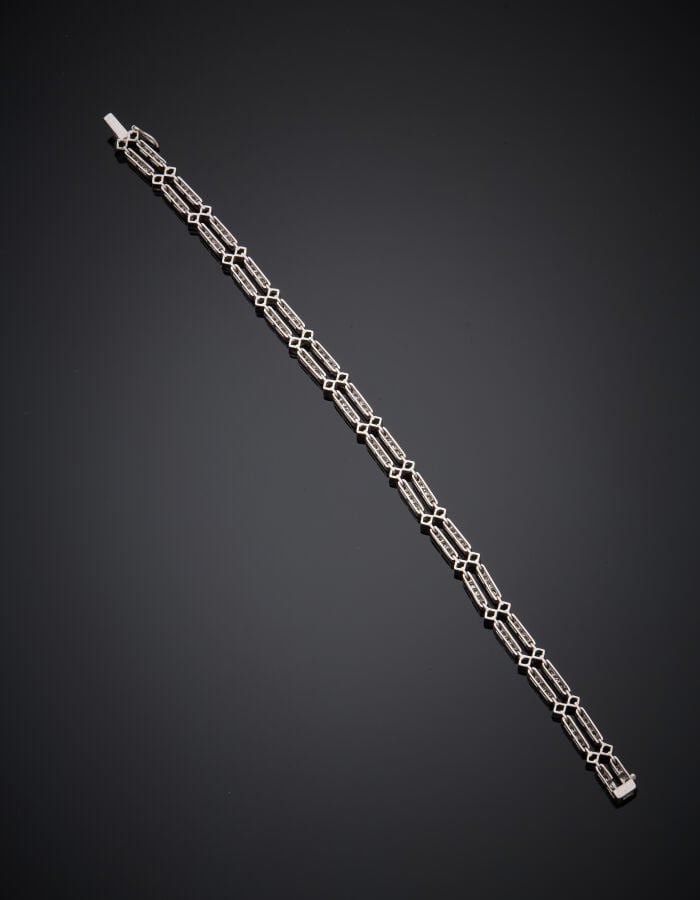 BRACELET géométrique en or gris (750‰) articulé, à motifs losangiques, serti de…