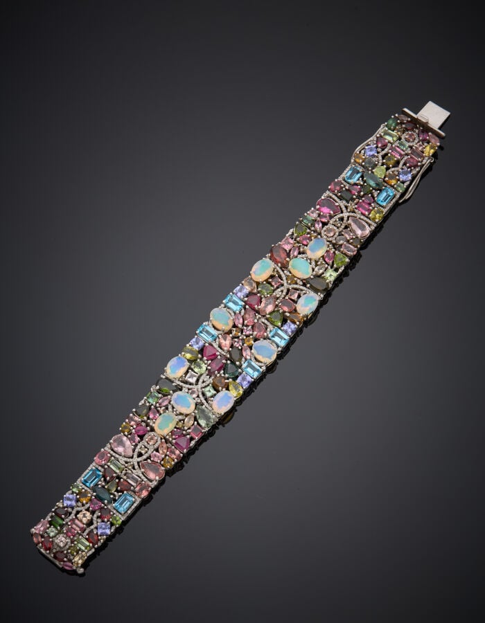 BRACELET manchette en argent (925‰) articulé et ajouré, serti de dix d'opales,…