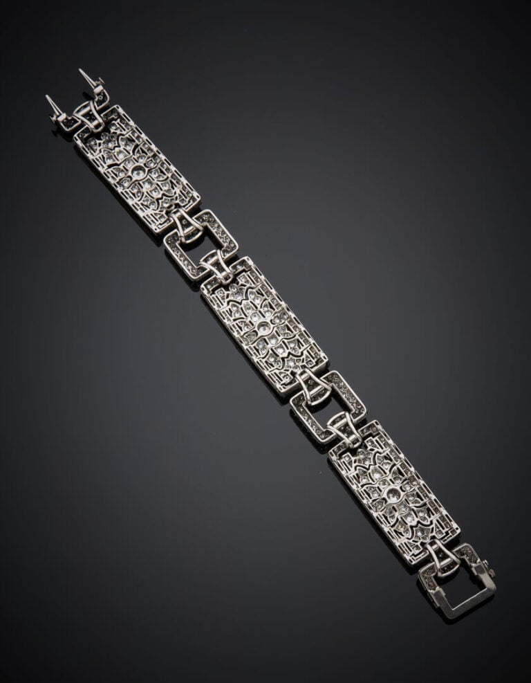 BRACELET manchette géométrique en or gris (750‰) ajouré, articulé, serti de dia…