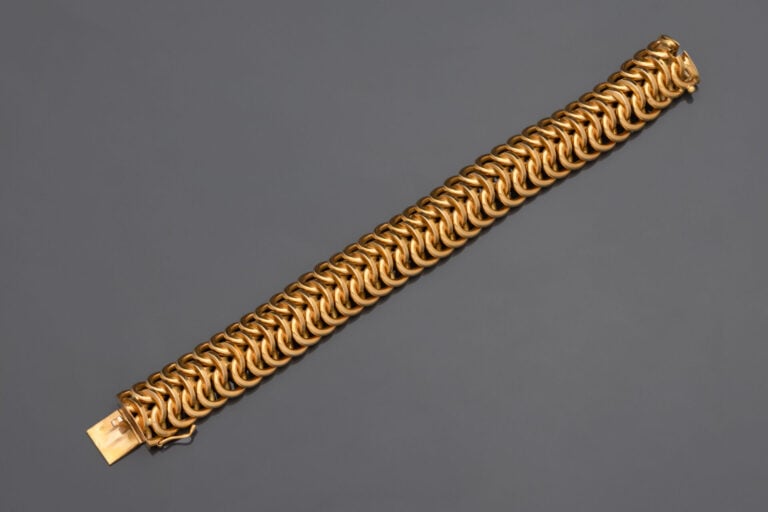 BRACELET manchette souple en or jaune (750°/°°) à motifs circulaires ajourés im…