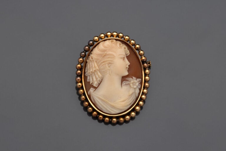 BROCHE ovale en or jaune (750°/°°) boulée serti d'un camée coquille figurant un…
