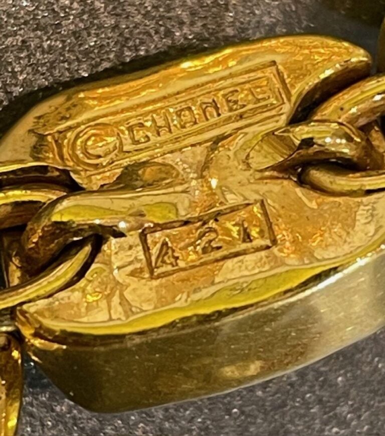 CHANEL - Bracelet articulé en métal doré orné de cabochons en pâte de verre rou…