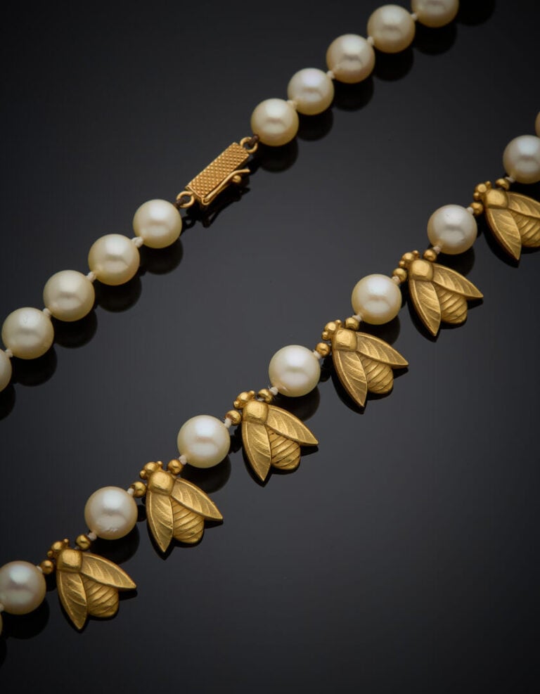 COLLIER composé d'un rang de perles de culture blanches, alterné de cinq motifs…