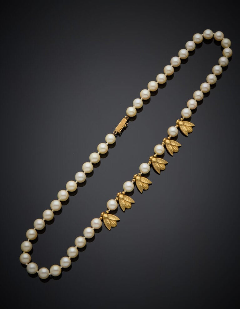 COLLIER composé d'un rang de perles de culture blanches, alterné de cinq motifs…