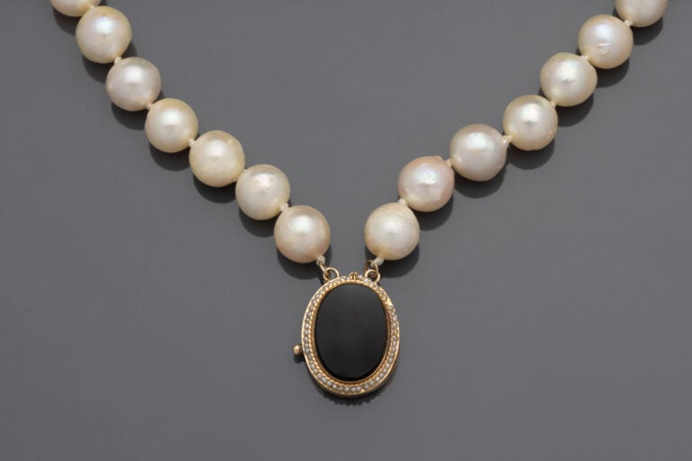COLLIER composé de 2 rangs de perles de culture blanches baroques. Fermoir oval…