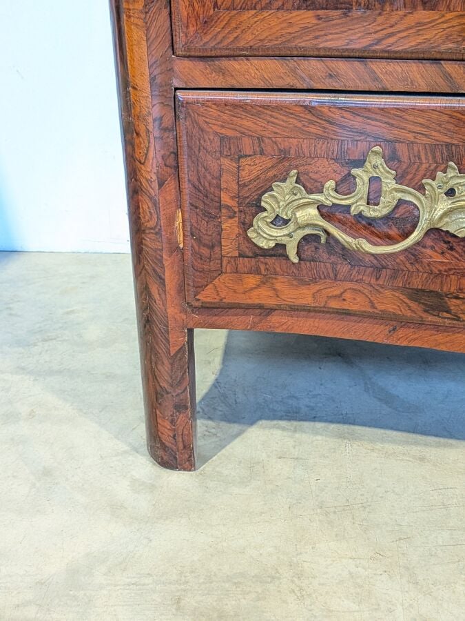 COMMODE galbée en placage de marqueterie ouvrant par trois tiroirs en façade ;…